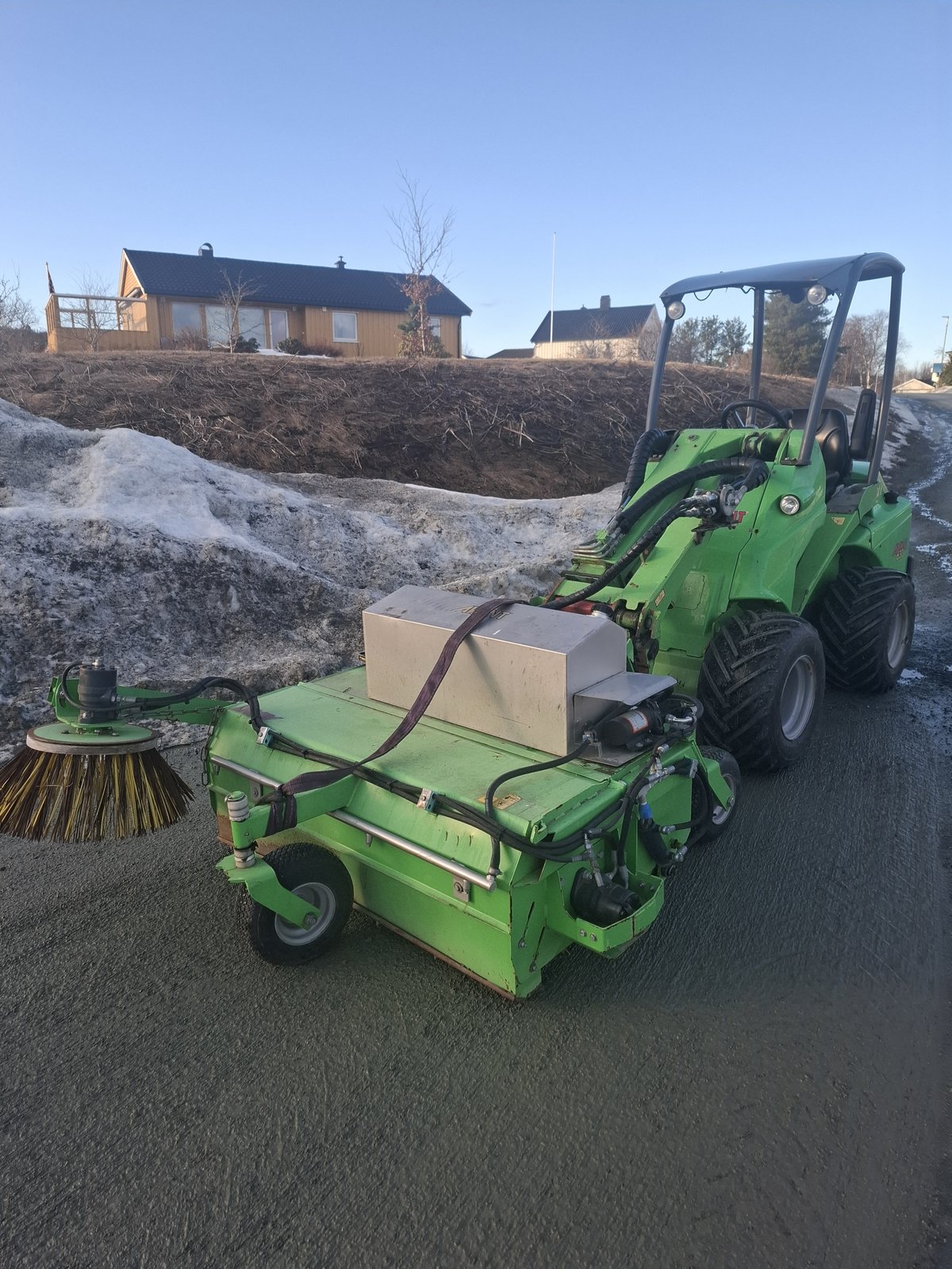 Grønn traktor med feier